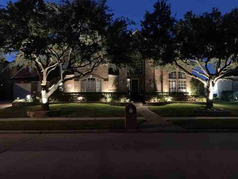 Well-lit house with surrounding trees with landscape lighting in Houston and surrounding areas